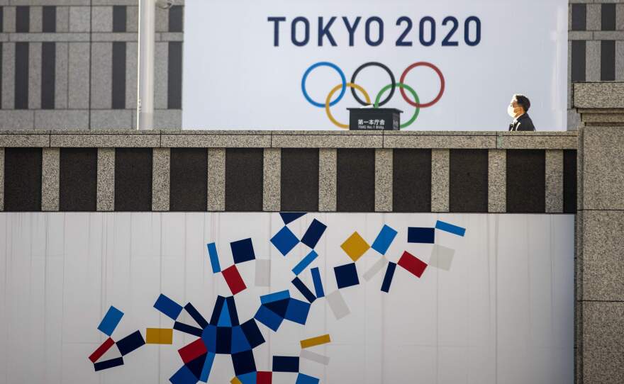 A pedestrian walks past an official Tokyo 2020 Olympic Games banner hanging on the Tokyo Metropolitan Government Building on Friday.