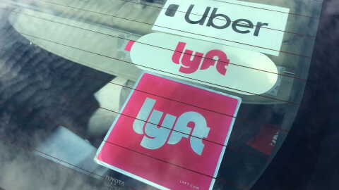 Uber and Lyft stickers are visible in the rear windshield of a car, Nov. 5, 2020.