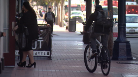 A bicyclists rides on the sidewalk of Broadway in downtown San Diego, Feb. 21, 2017.