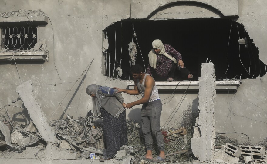 Palestinians evacuate a building damaged in the Israeli bombardment of the Gaza Strip in Rafah on Sunday.