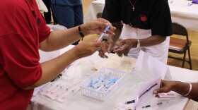 Priscilla Bramlette (Right), with the San Diego Black Nurses Association, prepares flu vaccine doses Friday morning at Martin Luther King Jr. Recreation Center in San Diego.