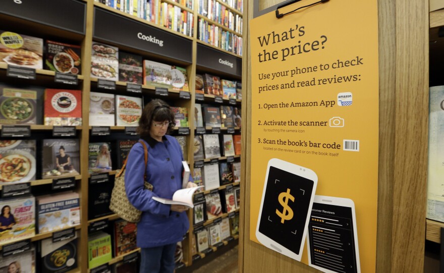 A customer looks at a book at Amazon Books, the first brick-and-mortar retail store for the online retail giant, on Nov. 3 in Seattle.