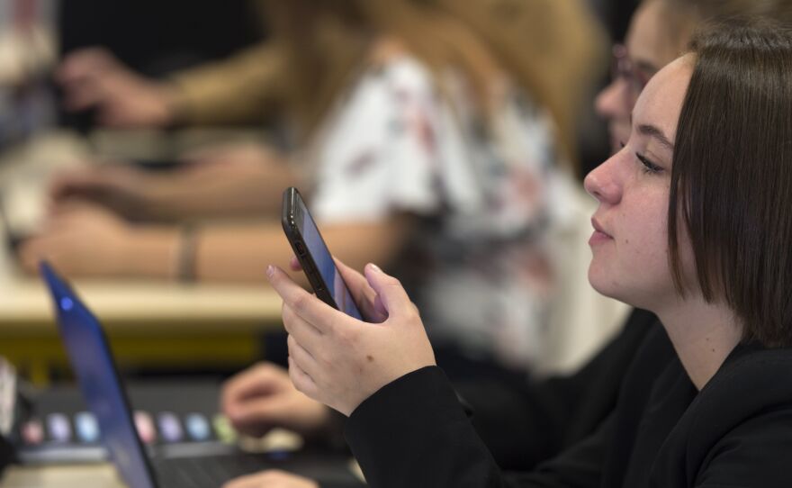 High school students use smartphones and laptops at a vocational school in Bischwiller, France, in September. The country's education minister said he will tighten the ban on phones for elementary and secondary school students, except for educational purposes and emergencies.