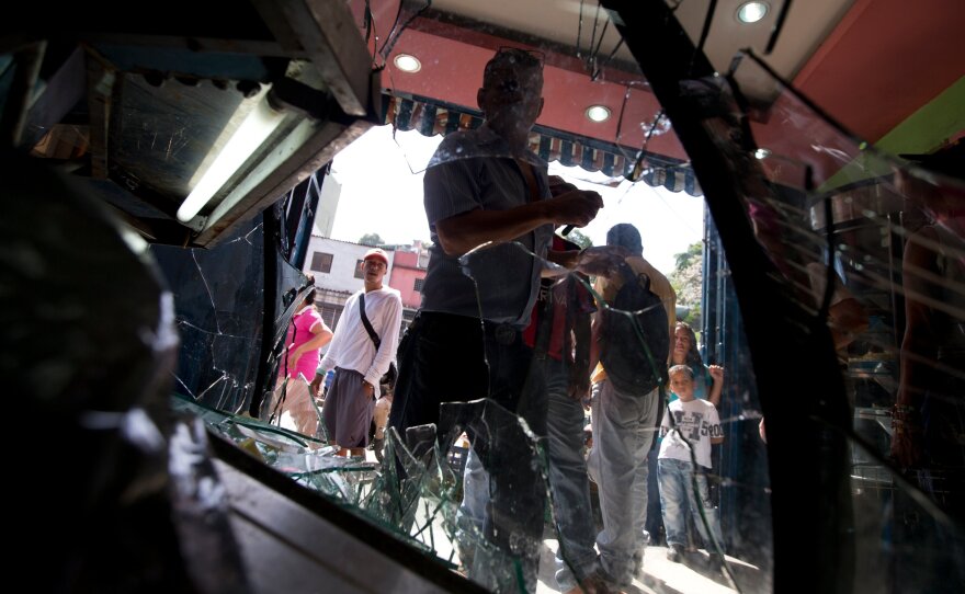 Customers enter a bakery in Caracus, Venezuela, on June 10, a day after it was looted.Bakeries and grocery stores are being ransacked in growing food-related violence in recent weeks.