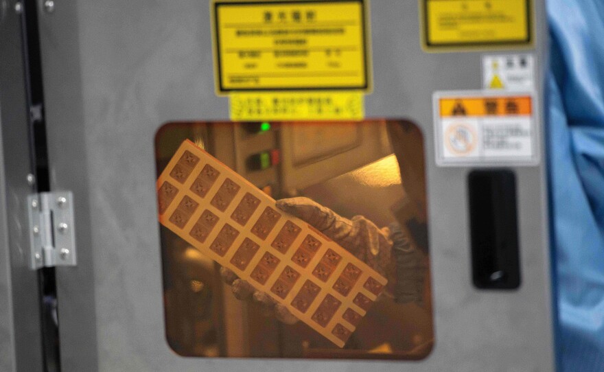 A worker is seen inside the production chain at Renesas Electronics, a semiconductor manufacturer, in Beijing on May 14, 2020. A global computer chip shortage is affecting automakers.