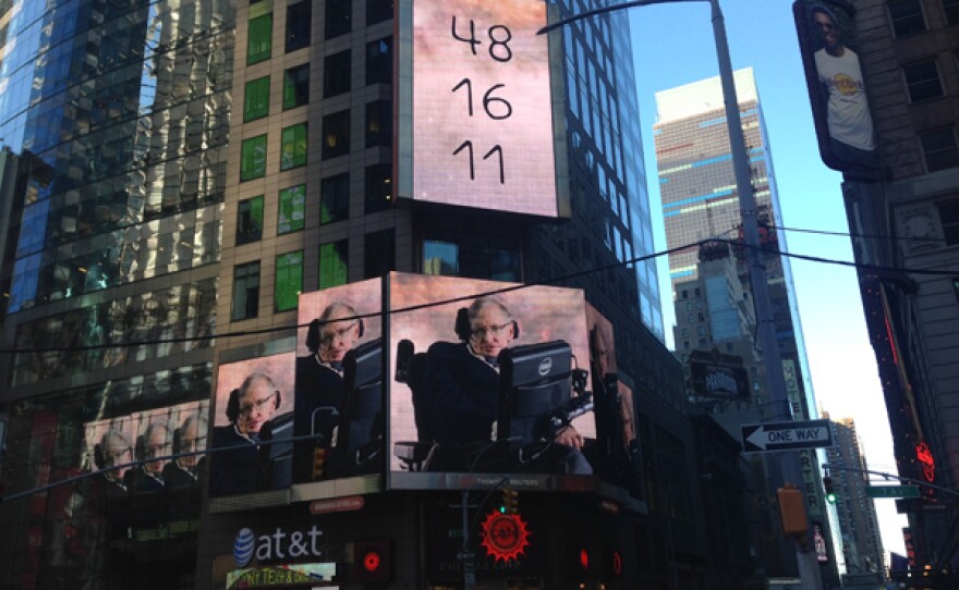 Stephen Hawking appearing on a billboard in Times Square as part of Demo 1. The volunteers are given a set of numbers which are coordinates, they had to work this out in order to get to a party invitation on time. This challenge looks at the difference between 3 dimensions and 4 dimensions and how we think about them.