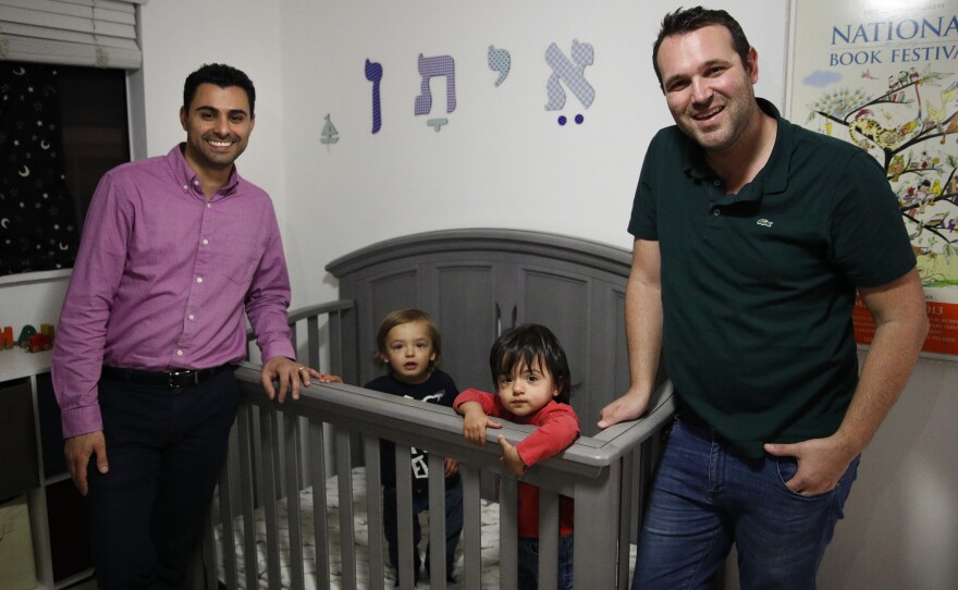 Elad Dvash-Banks (left) and his husband, Andrew, pose for photos with their twin sons, Ethan (right) and Aiden, in their Los Angeles apartment on Tuesday. Ethan is a plaintiff in a federal lawsuit against the State Department that seeks the same rights as his brother, who is a U.S. citizen.