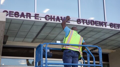 A worker removing César Chávez' name off the student services building at Southwestern College on March 19, 2026.