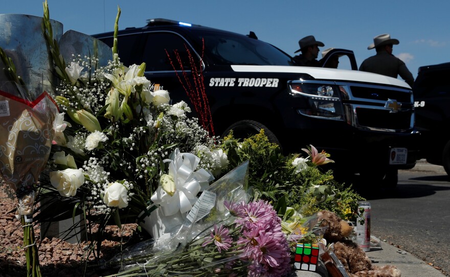 Flowers adorn a makeshift memorial near the scene of a mass shooting at a shopping complex Sunday in El Paso, Texas.