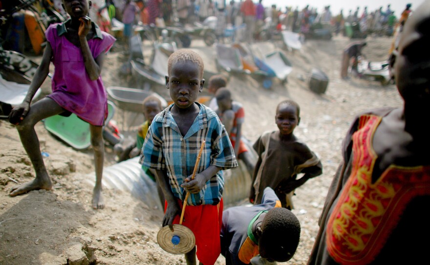 Kids play in front of a line for food rations at the camp. The 120,000 residents — the majority of whom are children — depend on distributions from the U.N. World Food Program.