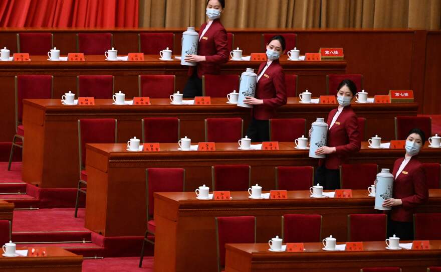 Attendants serve tea before the opening session of the congress.