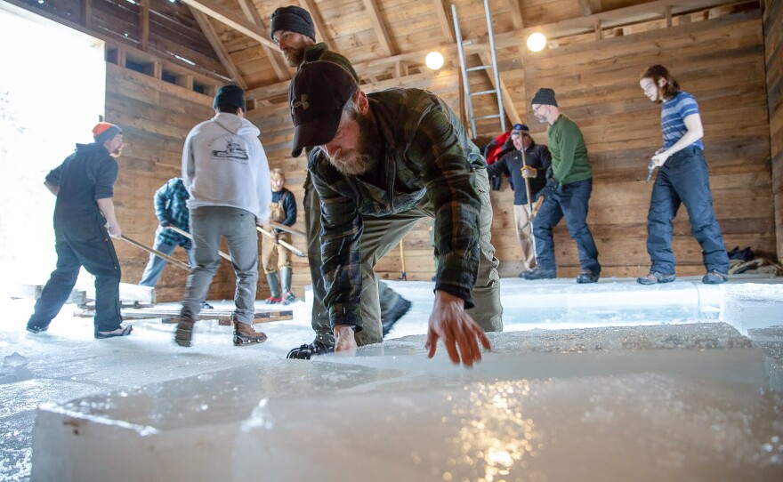 Ice "wranglers" stack blocks of ice in the ice house.