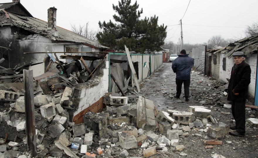Residents assess the damage caused by shelling between the Ukrainian army and pro-Russian separatists on Wednesday in the eastern Ukrainian city of Donetsk.