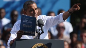President Obama holds a copy of "The New Economic Patriotism: A Plan for Jobs & Middle-Class Security," which outlines some of his agenda for a second term, during a rally in Richmond, Va., on Thursday.