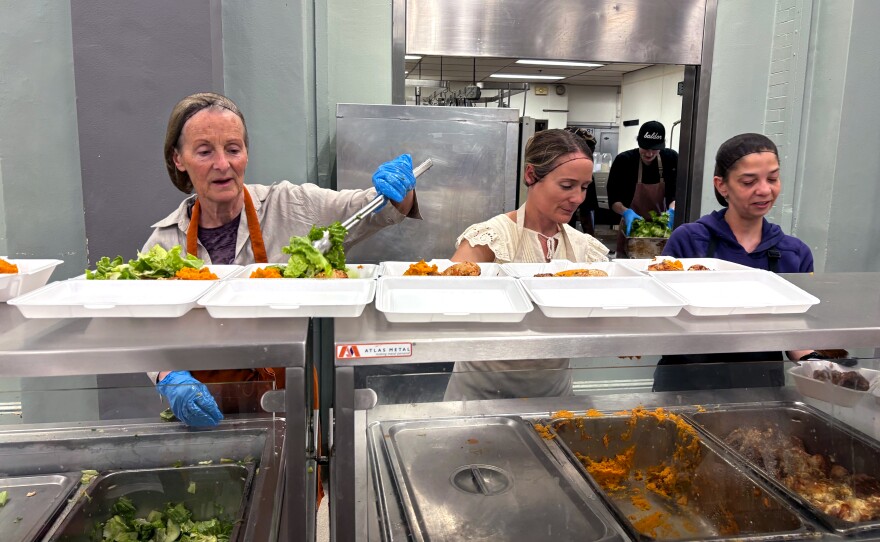Volunteers dole out hot dinners at the My Brothers Table soup kitchen in Lynn, Mass.