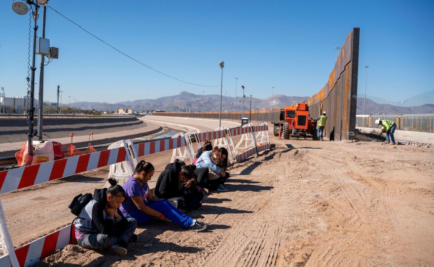 Salvadoran migrants wait for transportation after turning themselves in to U.S. Border Patrol agents in El Paso, Texas — where a border fence is under construction. The Pentagon says it will spend up to $1 billion to help build the fence.