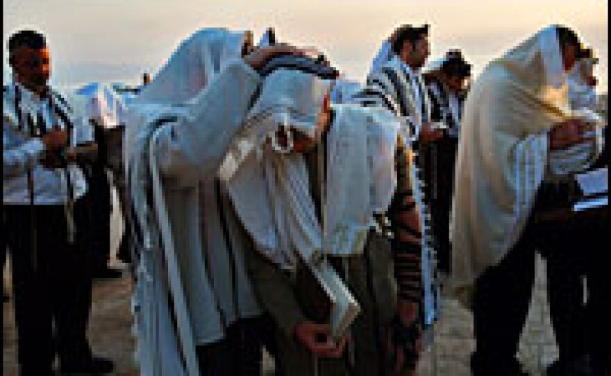 As the sun rises over the Sea of Galilee in northern Israel Wednesday, Jews cover themselves and their sons to receive the priestly blessing during the Blessing of the Sun.