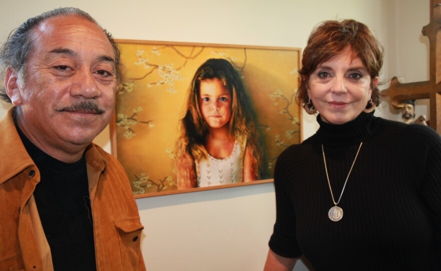 Jody and Reynaldo Terrazas stand in front of a painting of their oldest daughter. The Terrazases have lived in Oakland's San Antonio neighborhood for more than 40 years and raised two girls there.