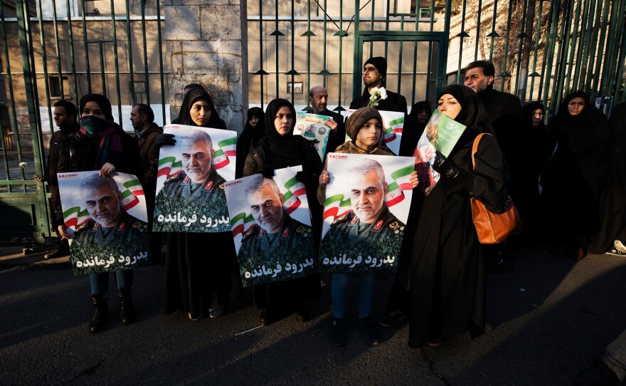 Crowds hold Soleimani's portrait while waiting for the traditional Muslim prayers for the dead to begin.
