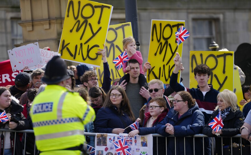Protesters wait for the arrival of King Charles III and Camilla, the queen consort, in Liverpool, England, on April 26. Dissenters will be among the cheering crowds when Charles travels to his coronation. More than 1,500 protesters will be dressed in yellow for maximum visibility, and they plan to gather along the parade route to chant "Not my king" as the royal procession goes by.