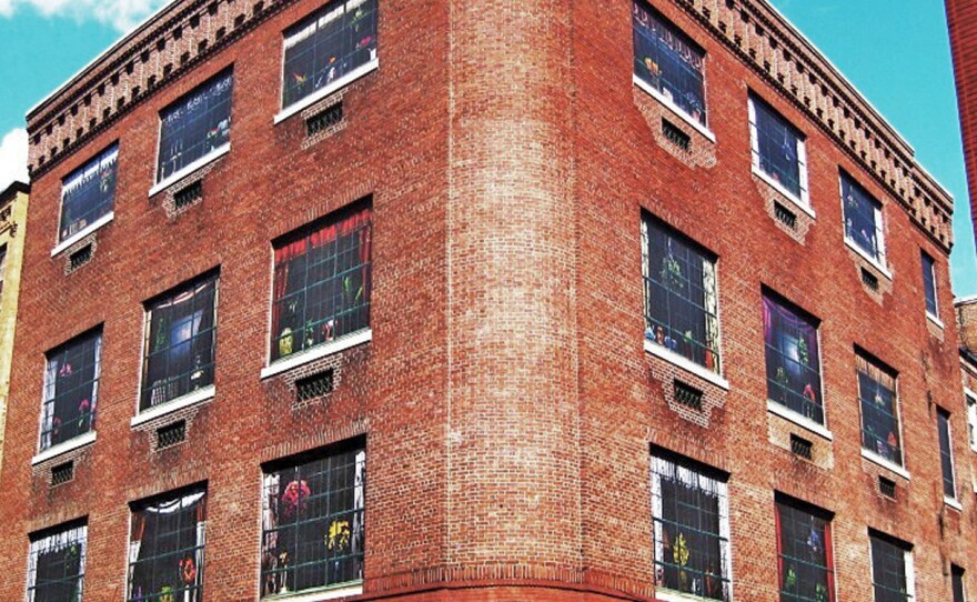 Swain covered boarded up windows of a 1909 electrical substation building in Boston with giant photos of furnished rooms.