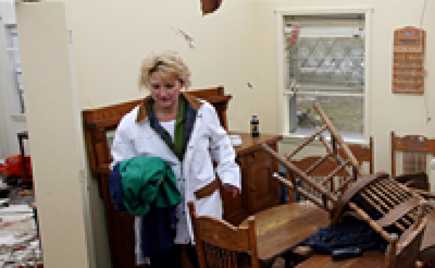 Becky Wilson searches through debris at her mother's house the morning after a tornado ripped through Atkins, Ark.