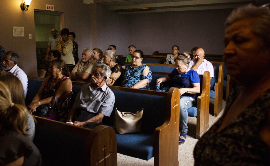Family and friends attend the funeral of Angélica Irizarry at the Funeraria Boneta in Lares. Because of the damage in the cemetery, Irizarry's son had to bury her in Camuy, 40 minutes away.