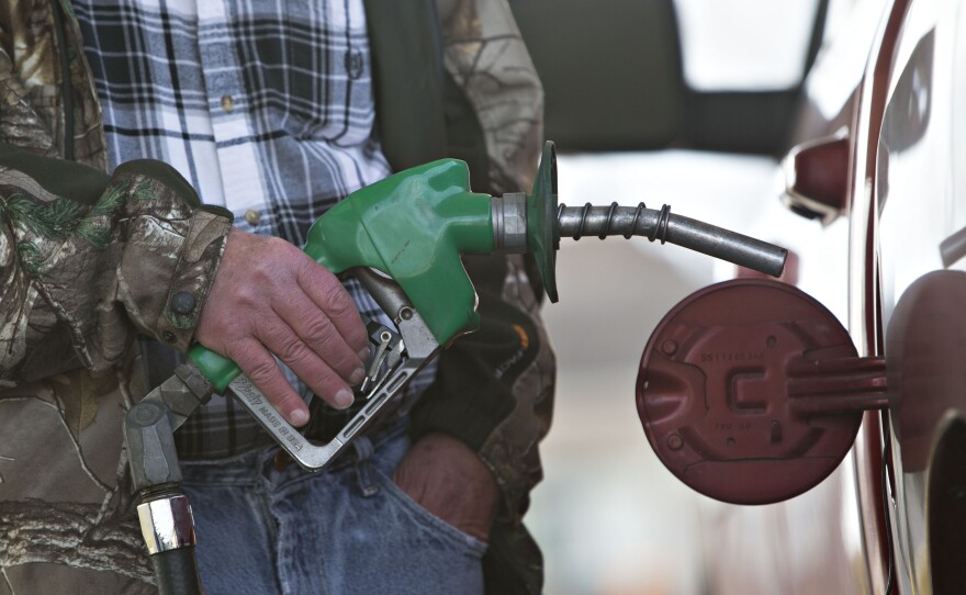 A customer fills up at a gas station in Chillicothe, Ill., in December. Low prices have meant big savings for consumers, but urban planners worry that cheap gas will encourage sprawl.
