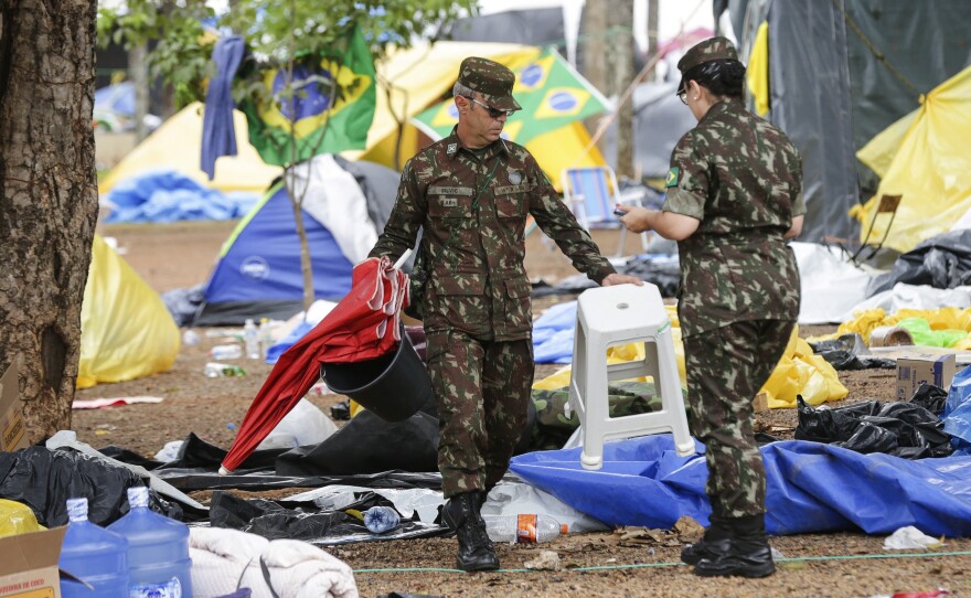 Soldiers help clear out an encampment set up by supporters of former Brazilian President Jair Bolsonaro outside army headquarters in Brasília on Monday, the day after Bolsonaro supporters stormed government buildings in Brazil's capital.