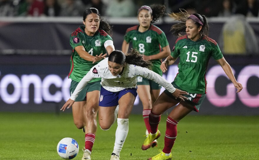 United States forward Sophia Smith, front, falls while vying for the ball against, from back left to right, Mexico defender Rebeca Bernal, midfielder Alexia Delgado and defender Cristina Ferral during a CONCACAF Gold Cup women's soccer tournament match, Monday, Feb. 26, 2024, in Carson, Calif.