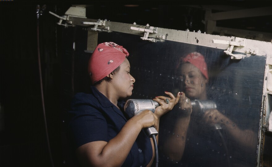 A woman wearing a bandana operates a rivet gun to assemble a Vultee A-31 “Vengeance” dive bomber at a Nashville, Tenn. factory.