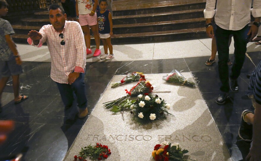 A man does a fascist salute as he stands next to the tomb of Francisco Franco inside the basilica at the Valley of the Fallen monument outside Madrid. Spain's center-left government approved legal amendments that it says will ensure that Franco's remains can soon be dug up and removed.