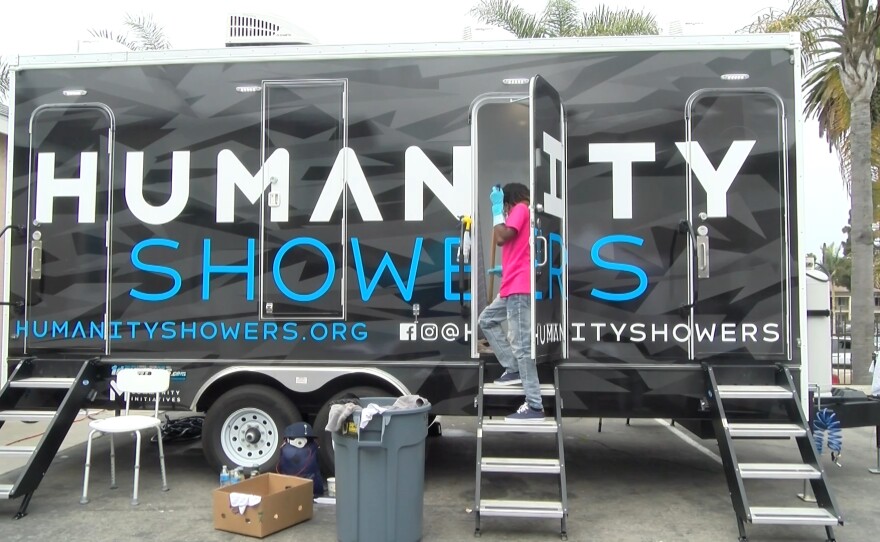 A volunteer sanitizes a shower stall from the Humanity Showers trailer in between guests. May 12, 2021.
