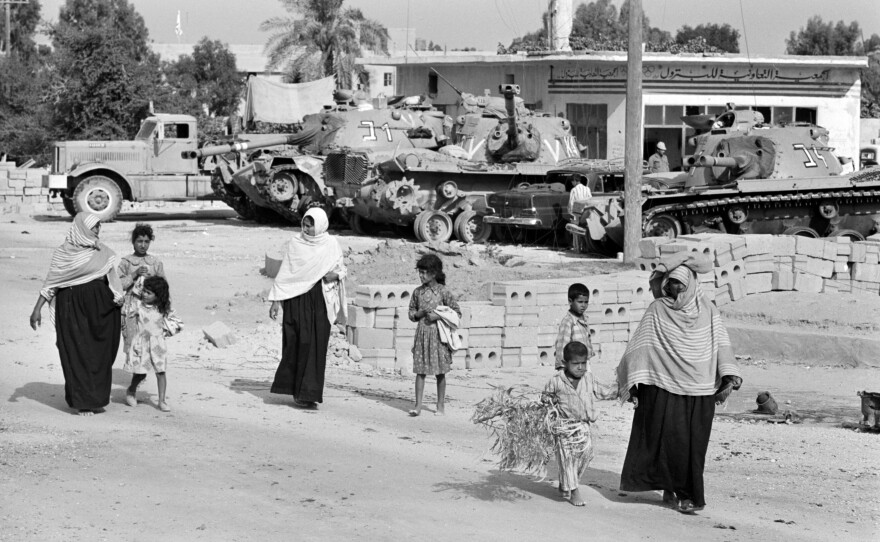 Gazans walk past Israeli army tanks during the Six-Day War in June 1967.