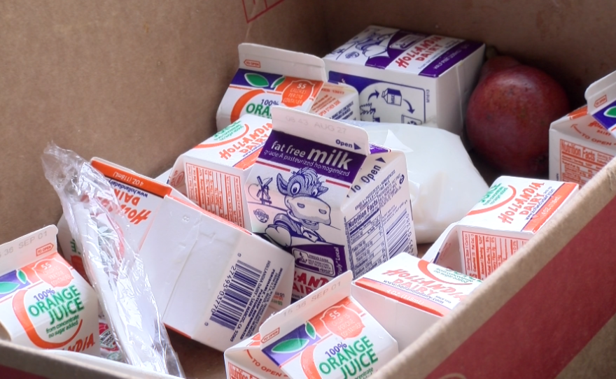 Discarded milk, orange juice and fruit fill a box at Castle Park Elementary School, Aug. 15, 2017.