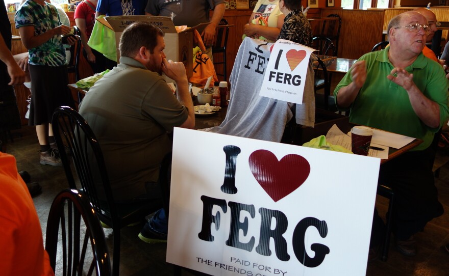 Ferguson residents pass out "I heart Ferg" yard signs at a local coffee shop.