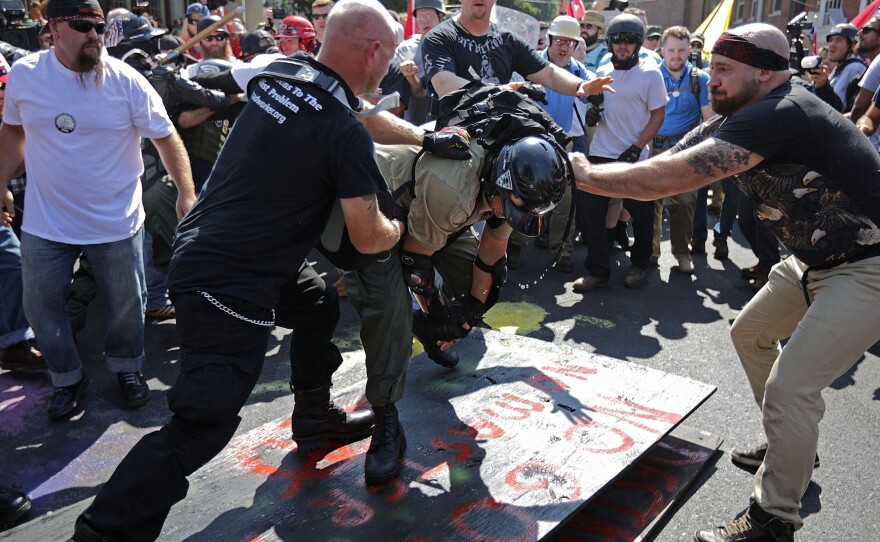 White nationalists, neo-Nazis, the Ku Klux Klan and members of the "alt-right" attack each other as a counter protester (R) intervenes during the melee at the Unite the Right rally August 12, 2017 in Charlottesville, Va.