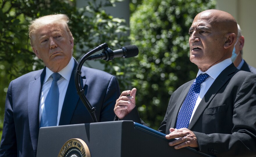 President Trump listens as Moncef Slaoui, the former head of GlaxoSmithKline's vaccines division, speaks about coronavirus vaccine development in May. Slaoui, an immigrant, is the chief adviser to Operation Warp Speed.