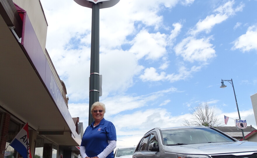 Donna Rogers shows off one of Cuba City's presidential lampposts.