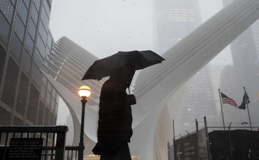 A man walks through snow during the morning commute in Manhattan on Tuesday.