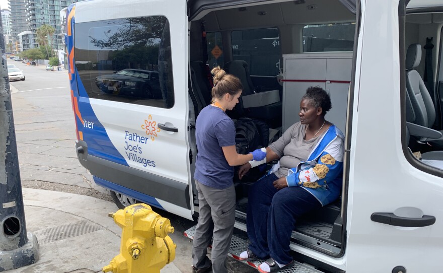 Kristan Horney, a nurse practitioner with Father Joe's Villages street health program, assisting a patient in a 2019 photo. 