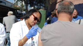 County nurse Jackie Kersey-Hardrick vaccinates a man in East Village in this undated photo. 