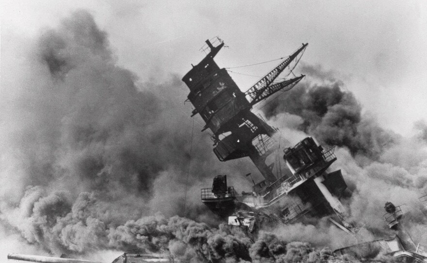 The battleship USS Arizona belches smoke as it topples over during the Japanese surprise attack on Pearl Harbor, Hawaii, on Dec. 7, 1941. The attack drew the U.S. into World War II.