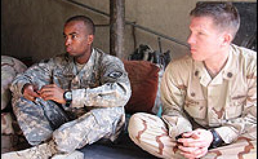 Army Lt. Kareem Hernandez and Cmdr. Larry LeGree sit in Omar village elder's house.