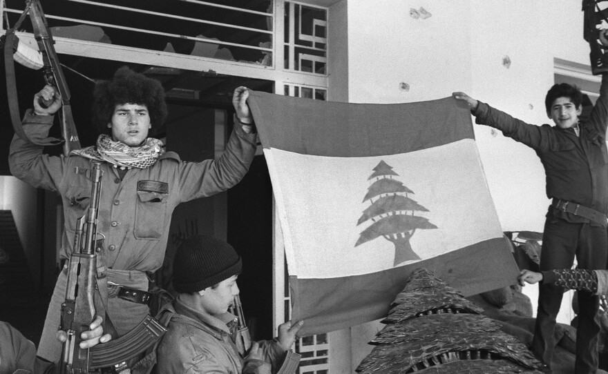 Palestinian fighters unfurl a Lebanese flag at the Holiday Inn after they dislodged Lebanese Christian forces on March 26, 1976. The hotel was a battleground throughout the 1975-90 Lebanese war, with its upper floors used as snipers' nests.