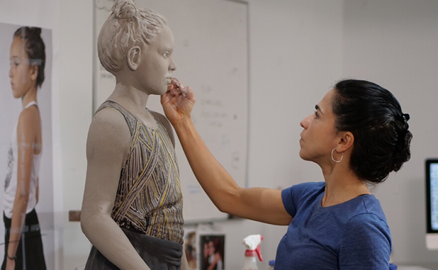 Cristina Córdova sculpting a life size figure in her studio.