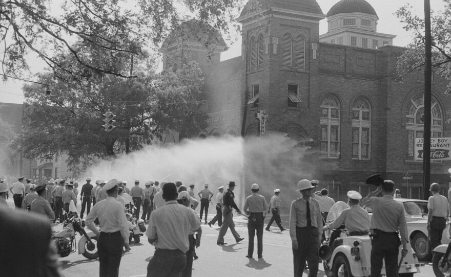 Police officers and fire fighters are called to quell unrest at the 16th Street Baptist Church, headquarters of the Birmingham Campaign in Birmingham, Ala., May 1963.