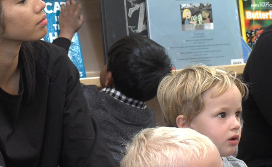 While his classmates listen to their teacher at the Mesa Child Development Center, a child who is new to the class plays with a book, April, 13, 2017.