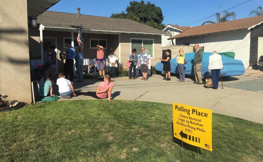 People line up to vote at a polling place at a home in San Diego, Nov. 8, 2016.