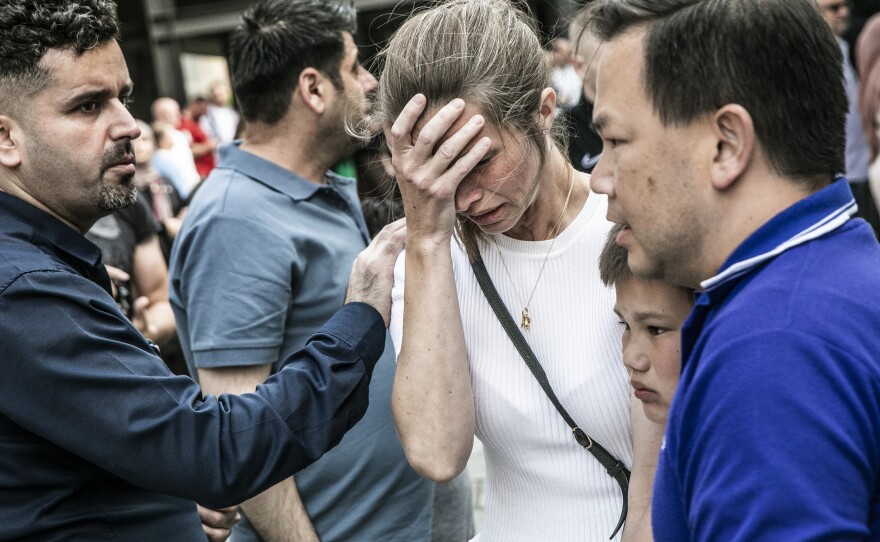 People react in front of the Field's shopping center in Copenhagen, Denmark Sunday, July 3, 2022. A gunman opened fire inside the busy shopping mall in the Danish capital Sunday.